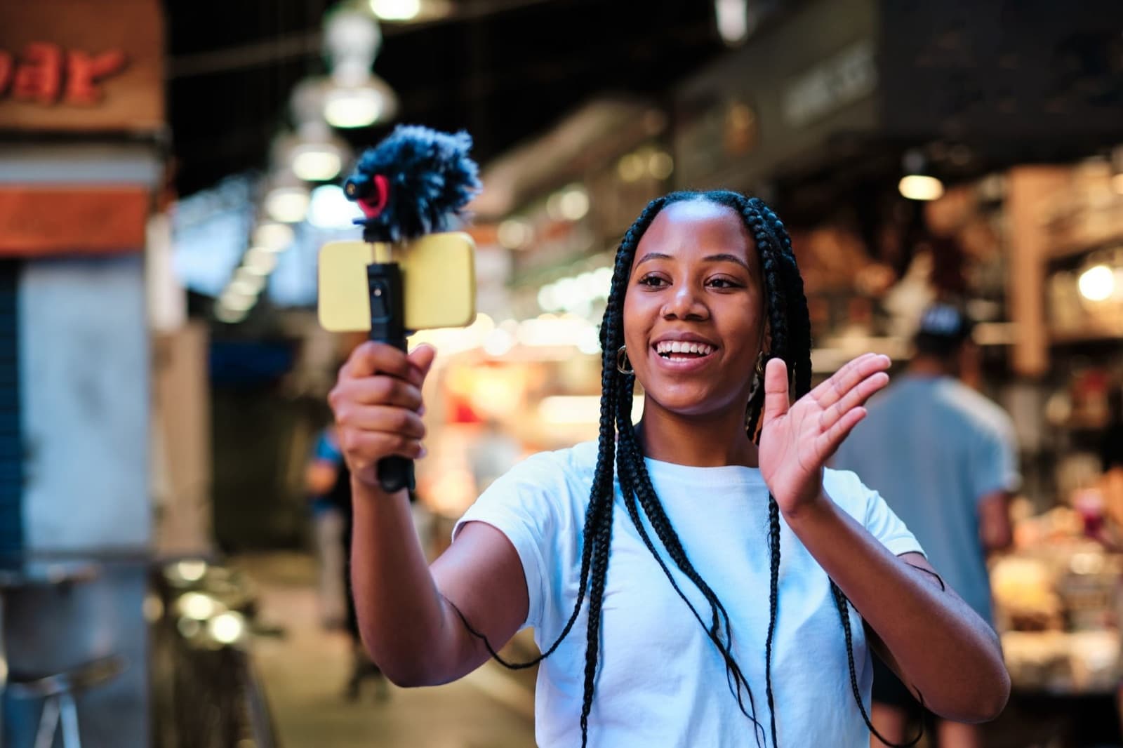 A local business owner films a handheld UGC video ad on a smartphone in a market.